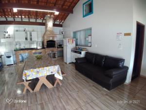 un salon avec un canapé et une table et une cuisine dans l'établissement Chácara Oliveira, à Socorro