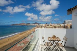 a balcony with a view of the beach and buildings at el Ático de Mateo 5A in Las Palmas de Gran Canaria