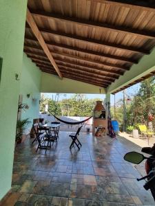 a porch with a hammock and a table and chairs at Chácara Cantinho da Paz in Ibiúna