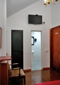 a bathroom with a toilet and a television on the wall at Hotel CALLI YOLOTL Teotihuacan in San Juan Teotihuacán