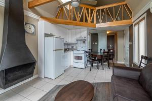 un salon avec cheminée et une salle à manger dans l'établissement Condo climatisé près du Mont Sainte-Anne avec parc aquatique, piscine, spa, gym, arcades et billard !, à Beaupré