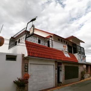 a building with a red roof and a garage at Hotel CALLI YOLOTL Teotihuacan in San Juan Teotihuacán