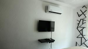 阿卡普爾科的住宿－書屋迪亞曼特濱海公寓，墙上配有平面电视的房间