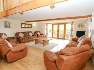 een woonkamer met leren banken en een tafel bij The Stables in Knighton