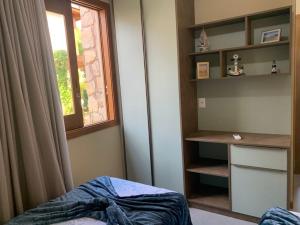 Dormitorio con ventana, cama y escritorio en Apartamento luxo Barra Grande Península de Maraú, en Maraú