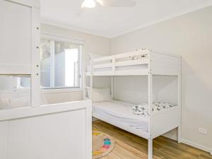 a white bunk bed in a white room with a window at A Perfect Ten in Cowes +20 photos