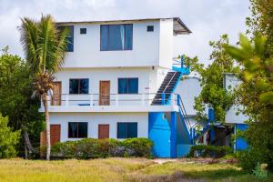 a house with a blue staircase in front of it at Hotel La Jungla in Puerto Villamil