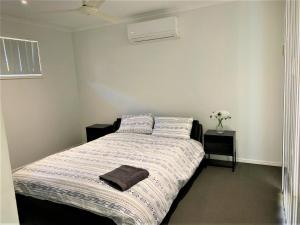1 dormitorio con 1 cama con 2 almohadas en Entire 4BR House close to Airport Hosted by Homestayz, en Gladstone