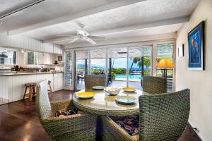 a kitchen and dining room with a table and chairs at Hale Pahukoa in Kailua-Kona