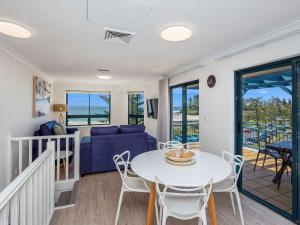 un soggiorno con divano blu, tavolo e sedie di Calypso Plaza Resort Unit 462 a Gold Coast