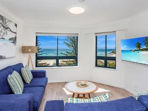 - un salon avec des canapés bleus et une table dans l'établissement Calypso Plaza Resort Unit 462, à Gold Coast