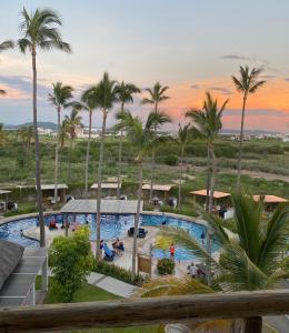 vista para uma piscina num resort com palmeiras em Palmilla residencial departamento en zona privada em Mazatlán