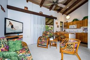 a living room with a couch and a tv and a table at Kona Makai 3-302 in Kailua-Kona