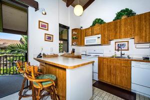 cocina con armarios de madera y encimera en Kona Makai 3-302 en Kailua-Kona