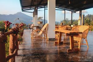 eine Terrasse mit Tischen und Stühlen und ein Tisch mit Stühlen in der Unterkunft Square Peg in Kandy