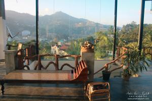 a chair on a balcony with a view of the mountains at Square Peg in Kandy
