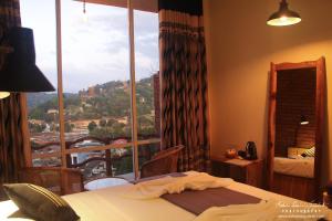 a bedroom with a bed and a large window at Square Peg in Kandy
