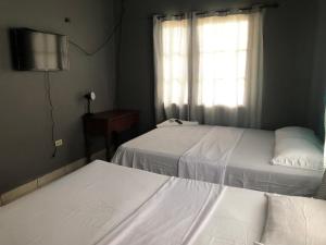 Postel nebo postele na pokoji v ubytování Hostal Rudy's Beach