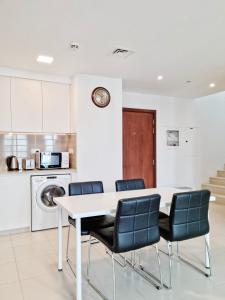 a kitchen with a white table and chairs at Al Qudra Town Square 2 Bedroom Duplex Apartment Dubai in Dubai