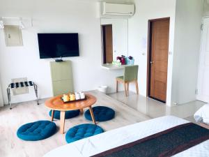 a living room with a table and chairs and a tv at 迎迎民宿 in Toucheng