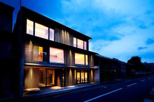 a building with lit windows on the side of a street at 2021年10月26日開業 枳殻邸別館 KIKOKUTEI Bekkan 26th October 2021 OPEN in Kyoto