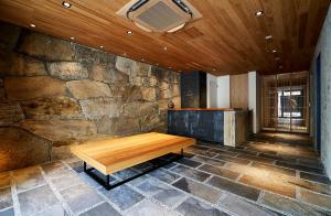 a wooden bench in a room with a stone wall at 2021年10月26日開業 枳殻邸別館 KIKOKUTEI Bekkan 26th October 2021 OPEN in Kyoto
