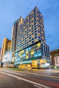 新山的住宿－Fives Hotel Johor Bahru City Centre，城市街道上一座高大的建筑,有很多窗户