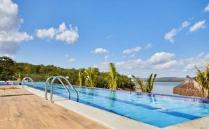 a large swimming pool next to a body of water at Apartamento Resort do Lago in Caldas Novas