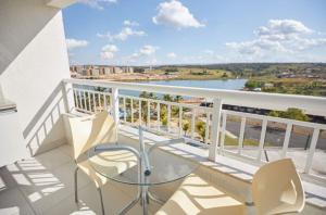 a balcony with a glass table and chairs on a balcony at Apartamento Resort do Lago in Caldas Novas