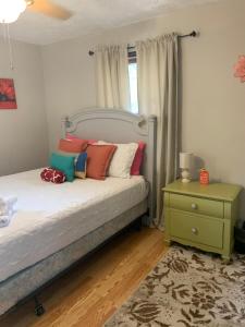 a bedroom with a bed with colorful pillows and a night stand at Jackson’s Stone Mountain Hideaway in Stone Mountain