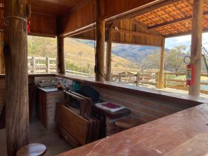 a room with a counter and windows with a view at Casa Amarela in Passa Quatro
