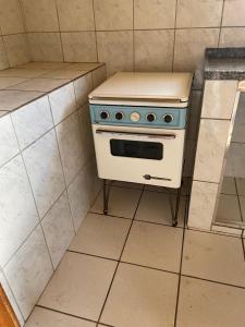 um fogão numa cozinha com piso em azulejo em Casa Amarela em Passa Quatro