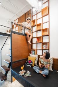 a man and a woman sitting on a bunk bed at Book a Bed Poshtel - SHA Plus in Phuket Town