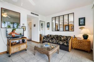Una sala de estar con un sofá y un televisor. en Kona Plaza#402, en Kailua-Kona