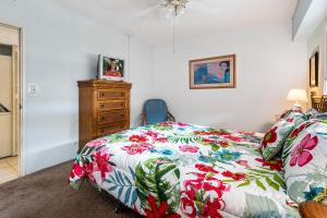 Un dormitorio con una cama y una cómoda con una manta colorida. en Kona Plaza#402, en Kailua-Kona