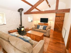 a living room with two couches and a tv at Nant Bach in Pwllheli