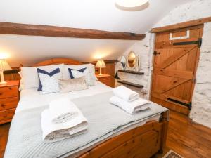 a bedroom with a wooden bed with towels on it at Nant Bach in Pwllheli