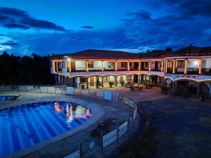 a large building with a swimming pool at night at Hotel Gran Sirius in Sáchica