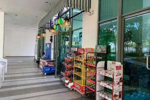 a store aisle of a grocery store with a person sitting inside at Cosy Studio Netflix SelfCheckIn Cyberjaya 3 in Cyberjaya
