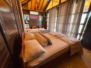 a bedroom with a large bed with two pillows at Compass Atauro Eco Lodge in Beloi