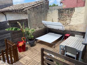 a patio with a bench and a table and a chair at Dépendance cosy climatisée jacuzzi diner aux chandelles in Vauvert