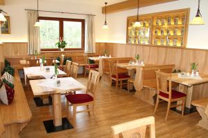 una sala da pranzo con tavoli e sedie in legno di Hotel-Gasthof Kramerwirt a Irschenberg