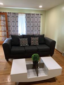 uma sala de estar com um sofá preto e uma mesa de centro em Niagara Falls Private Brick Vacation Home em Niagara Falls