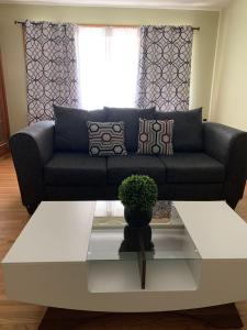 a living room with a black couch and a coffee table at Niagara Falls Private Brick Vacation Home in Niagara Falls