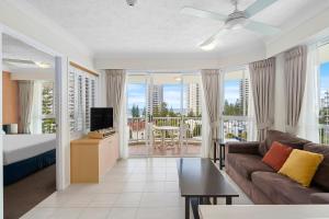 a living room with a couch and a tv at Surf Parade Resort in Gold Coast