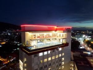 a tall white building with a neon sign on top of it at The ZHM Premiere Padang in Padang
