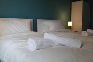 uma grande cama branca com lençóis e almofadas brancos em LARGE 12 Guests 5 Bedroom House in Birmingham City Centre em Birmingham