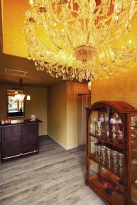 a chandelier in a room with a wooden floor at Aubergeフレンチの森 in Kusumoto