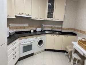a kitchen with a washing machine and a sink at Churruca Center 2 hab in Vigo