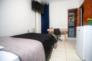 a bedroom with a bed and a desk and a television at Gran Imperial Avenida in Tumbes +36 photos